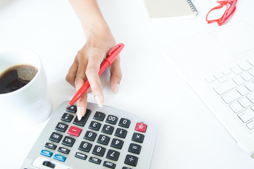 Business woman using calculator and laptop on white desk, Accounting and tax concept