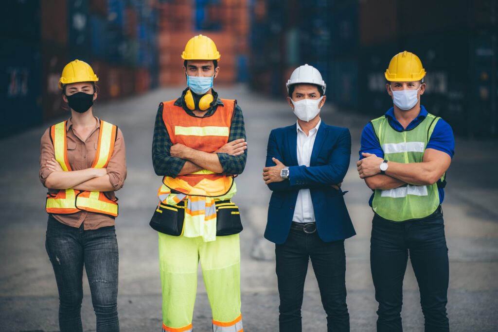 Factory workers team with businessman engineer and foreman wear medical face mask
